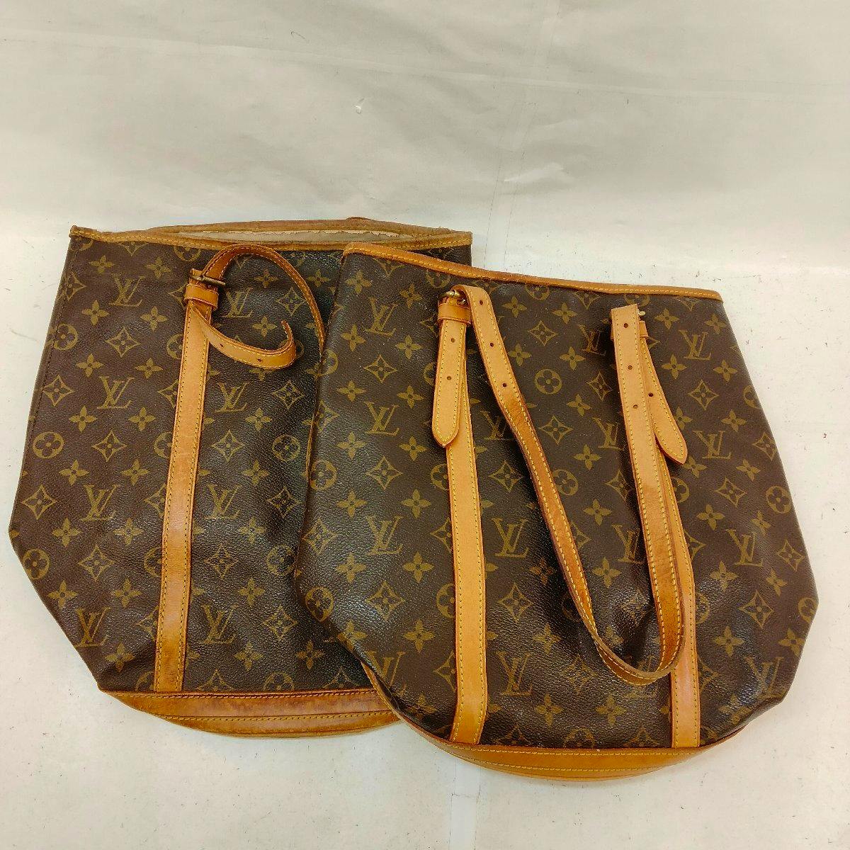 Two Louis Vuitton monogram canvas bucket bags laid flat showing the exterior and leather straps.