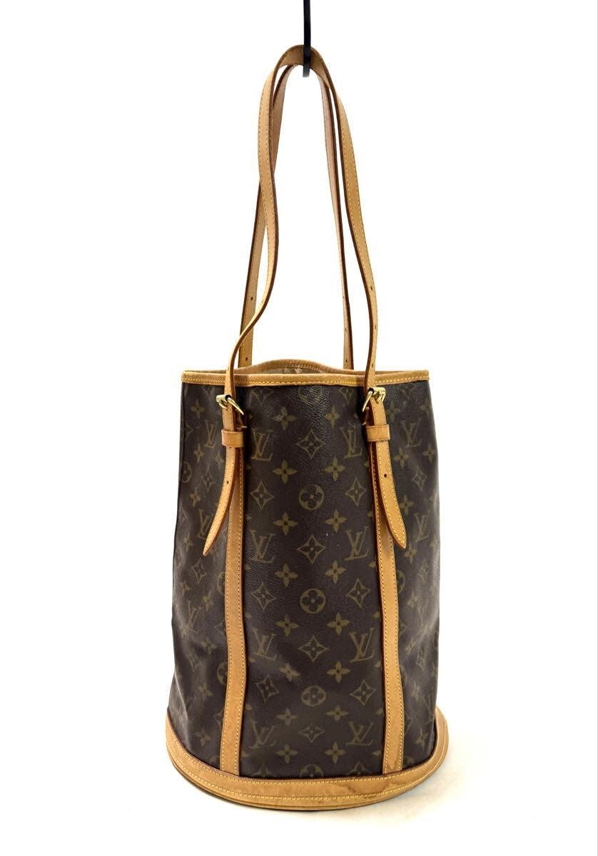 Louis Vuitton monogram Bucket GM shoulder bag hanging with long leather straps.