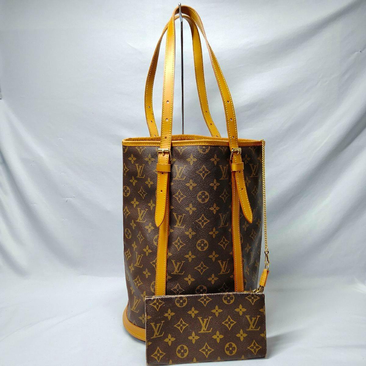 Front view of the Louis Vuitton Monogram Bucket GM tote bag with attached monogram pouch against a plain background.