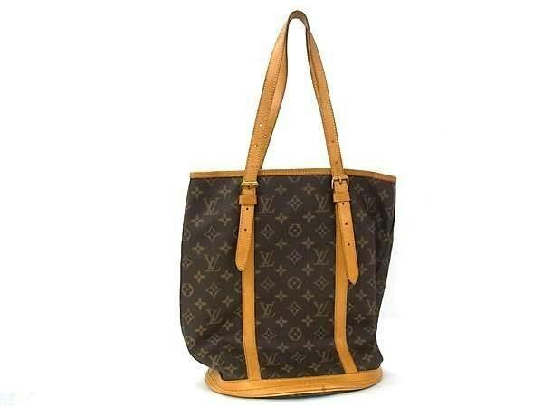 Brown Louis Vuitton monogram Bucket GM tote bag with tan leather straps on a white background.
