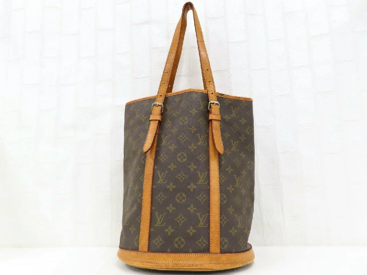 Front view of a Louis Vuitton monogram bucket tote bag in canvas with leather trim and shoulder straps.