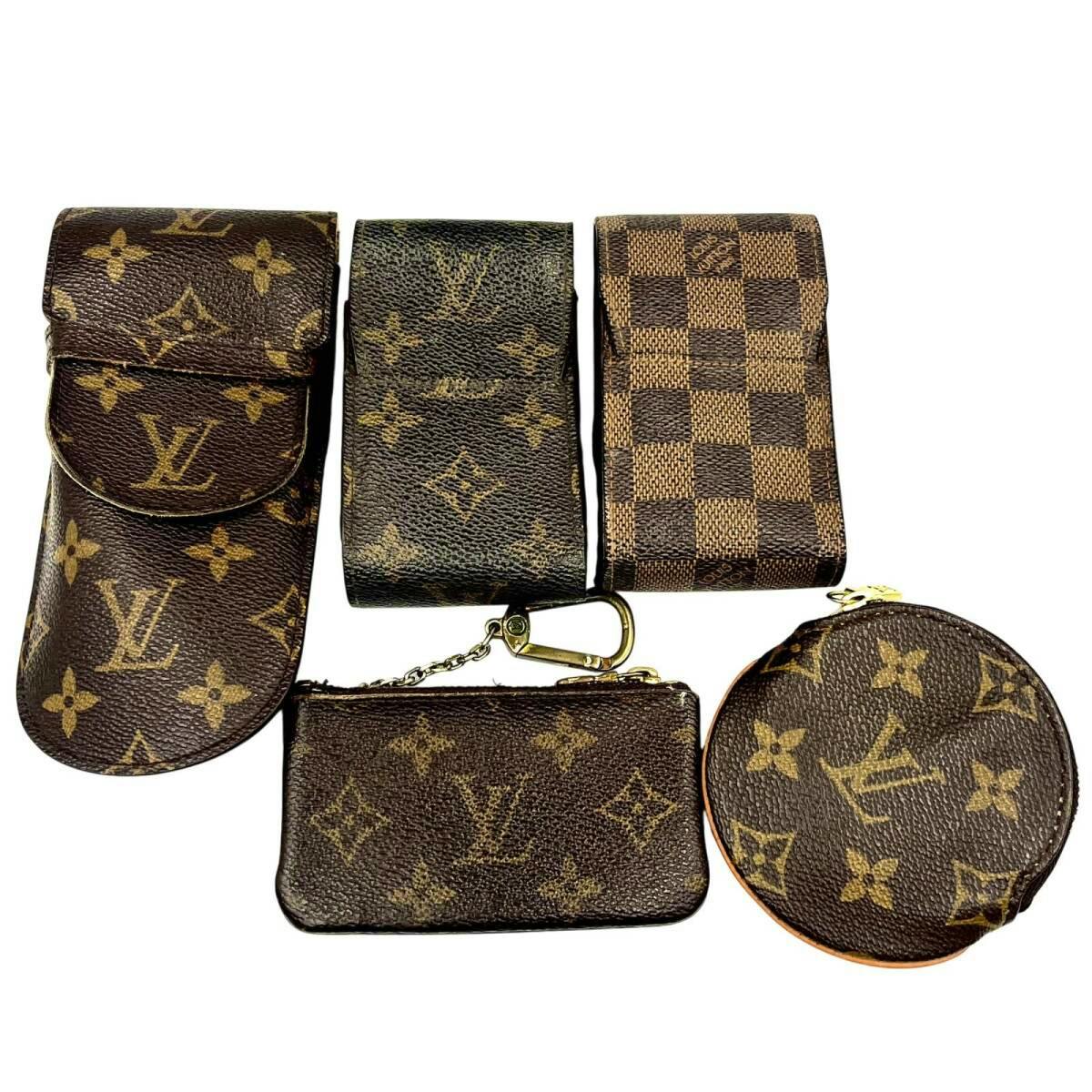 Five Louis Vuitton small accessories in monogram and Damier canvas arranged on a white background.