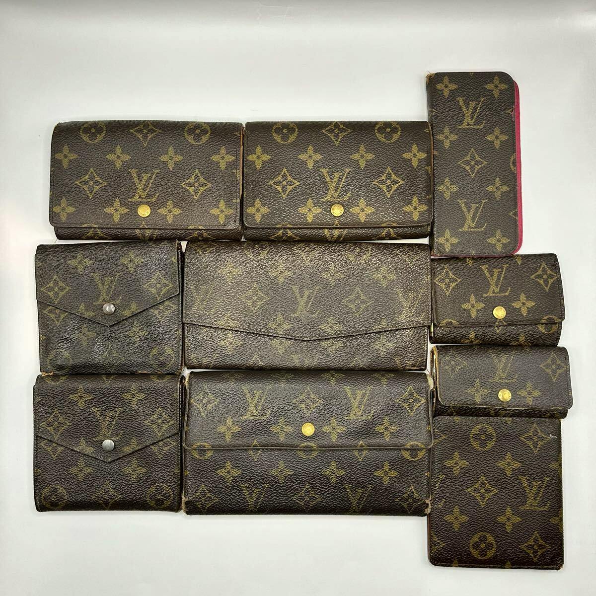 A bulk set of Louis Vuitton monogram canvas wallets and key cases arranged on a white background.