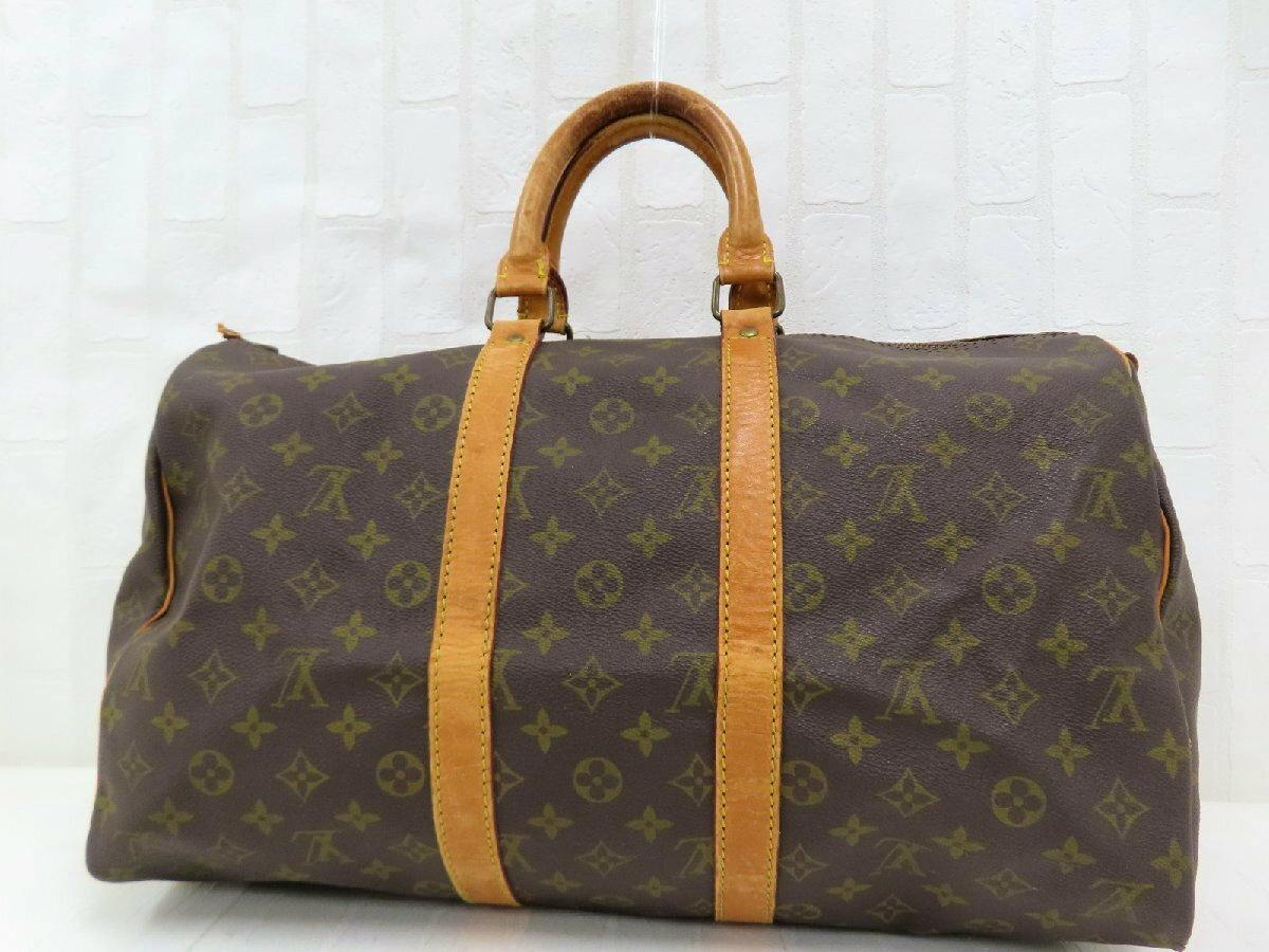 Front view of a Louis Vuitton monogram canvas Boston bag with brown leather trim and top handles.