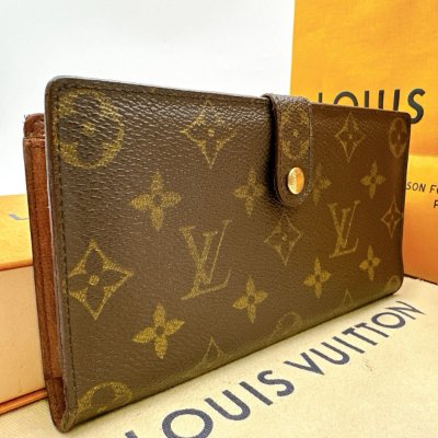 A Louis Vuitton monogram continental clutch bifold wallet with snap closure displayed on a Louis Vuitton box.
