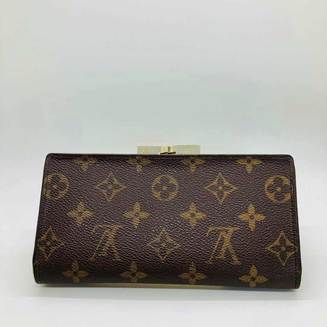Brown Louis Vuitton monogram continental clutch wallet in cow leather shown flat with the clasp visible.