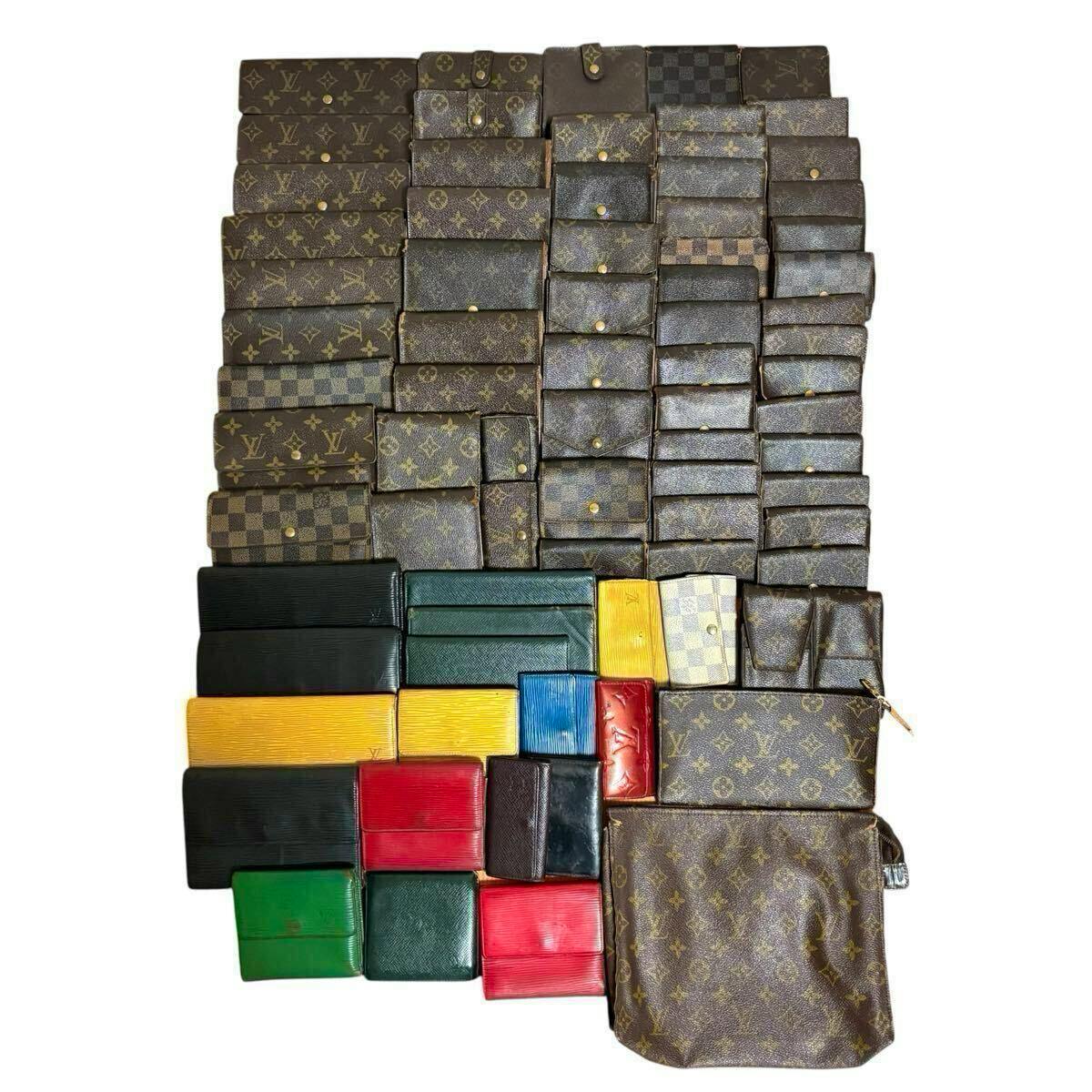 A large assortment of Louis Vuitton wallets, pouches, and small leather goods in monogram, Damier, and colored leathers arranged on a white background.