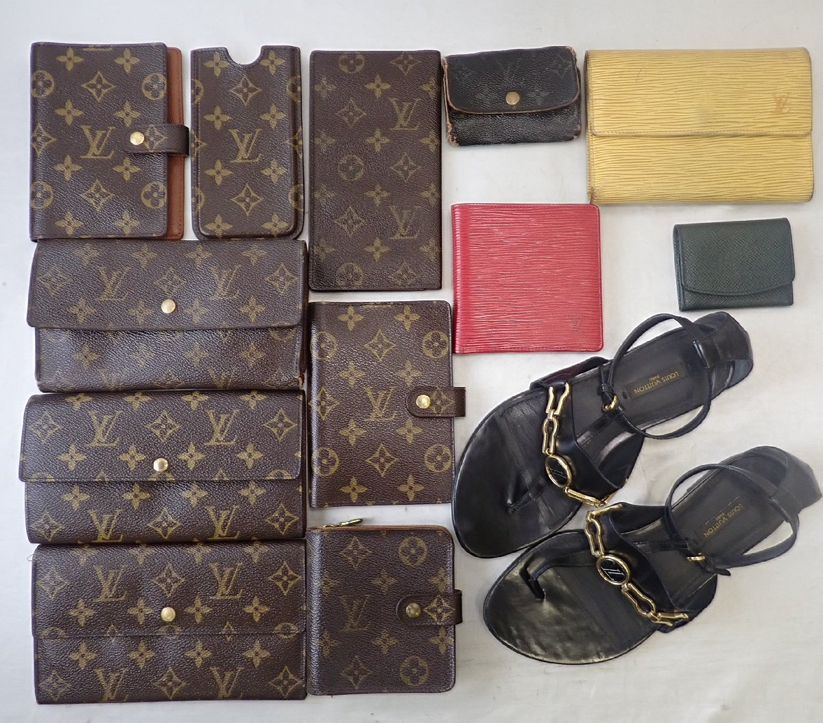 Several Louis Vuitton monogram and leather wallets and small accessories arranged flat on a surface.