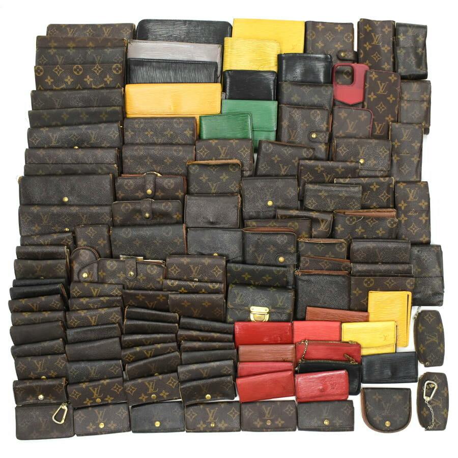A large assortment of Louis Vuitton wallets and small leather goods (about 120 pieces) in monogram and Epi styles arranged on a white background.