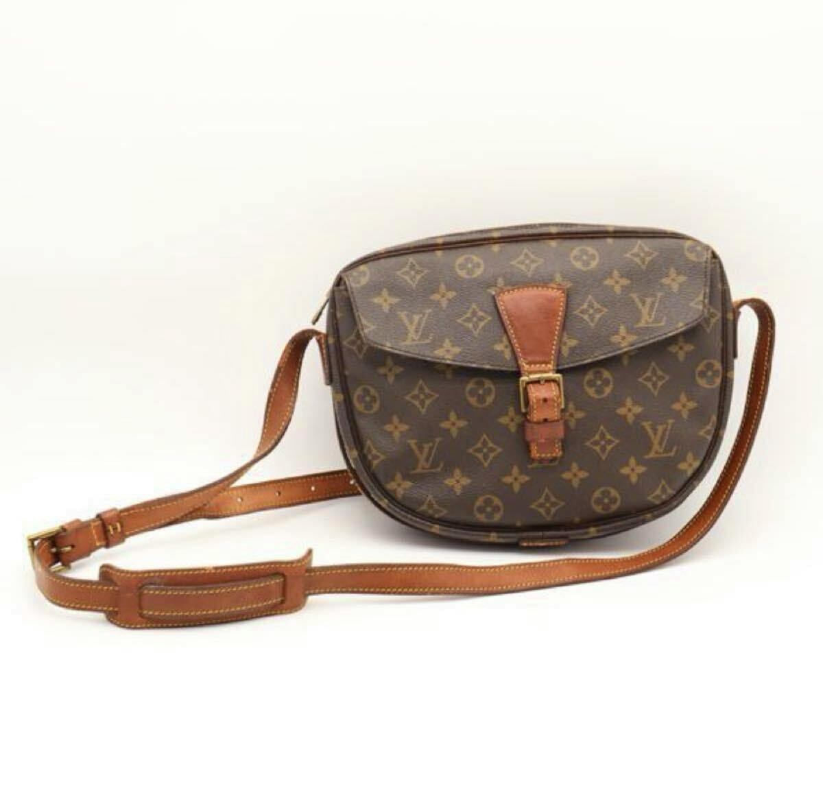 Front view of the LOUIS VUITTON monogram Jeune Fille shoulder bag with brown leather strap and buckle on a white background.