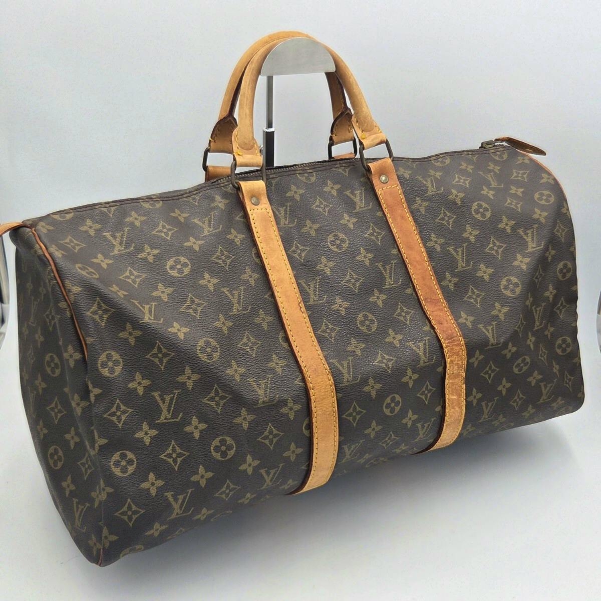 Louis Vuitton monogram Keypol 50 duffel/boston bag with leather handles photographed on a plain background.