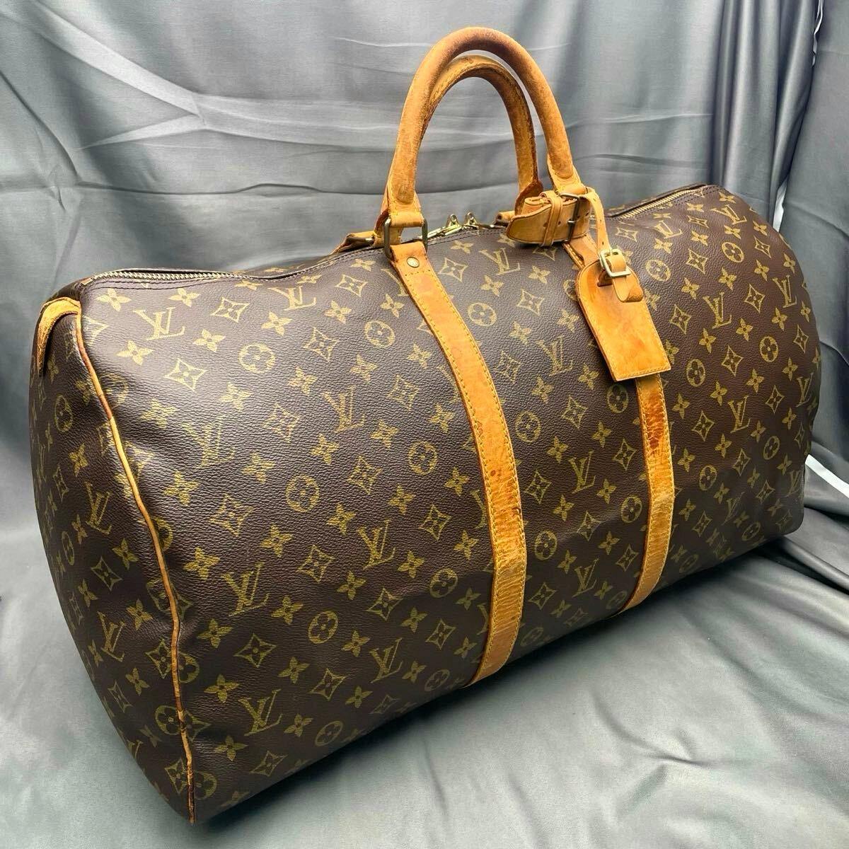Louis Vuitton monogram Keypol 55 (M41414) canvas duffel bag with leather handles and straps on a gray fabric background.