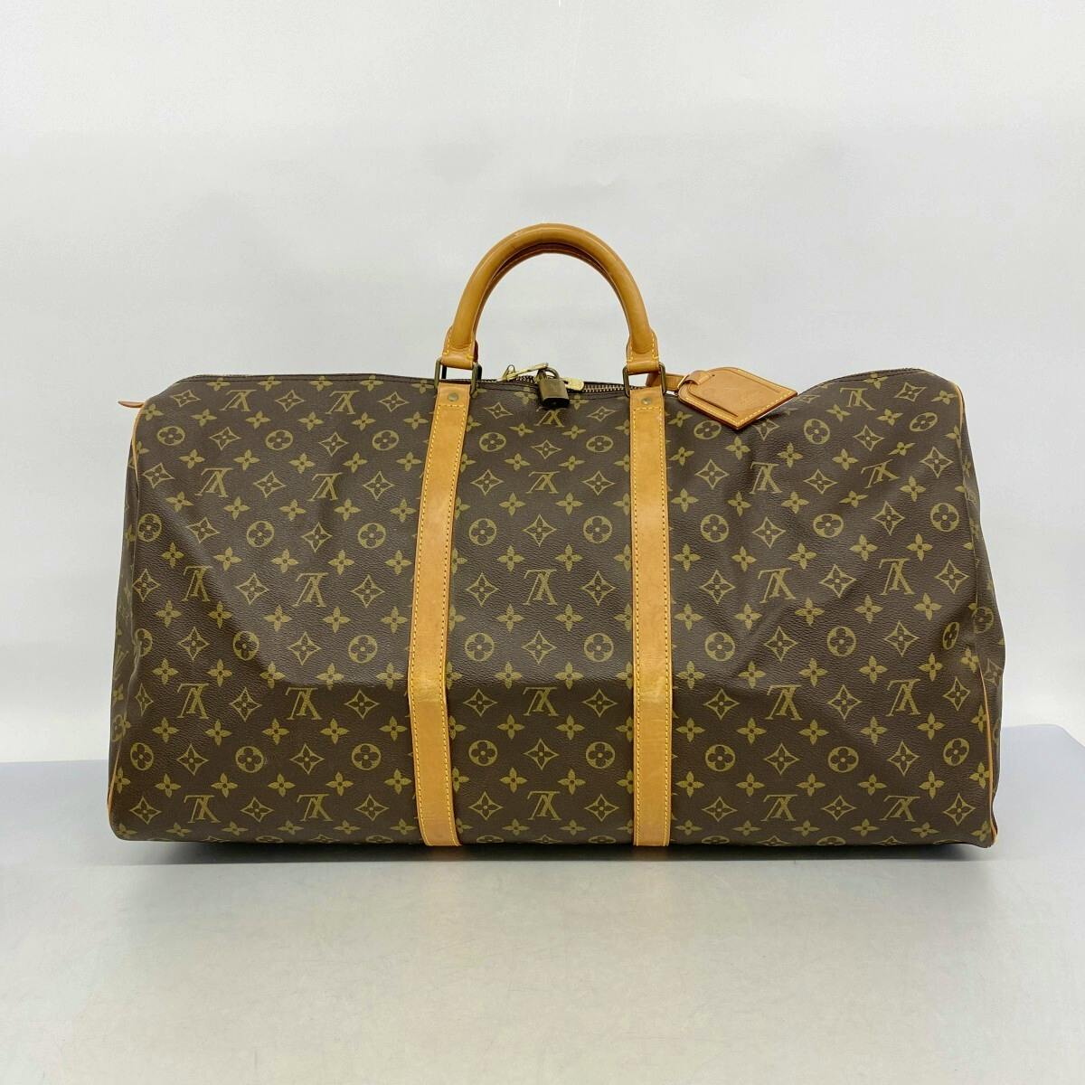 Brown Louis Vuitton Monogram Keepall 60 (M41422) duffel bag with tan leather handles and straps photographed from the front on a light background.