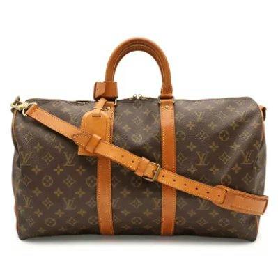 Front view of a Louis Vuitton monogram Keepall Bandouliere 45 duffel bag with leather handles and an adjustable shoulder strap.