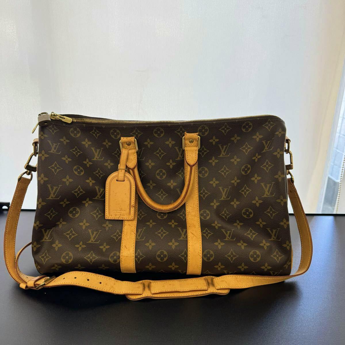 Front view of the LOUIS VUITTON monogram Keypol/Bandoulière 45 Boston bag with tan leather handles and shoulder strap.