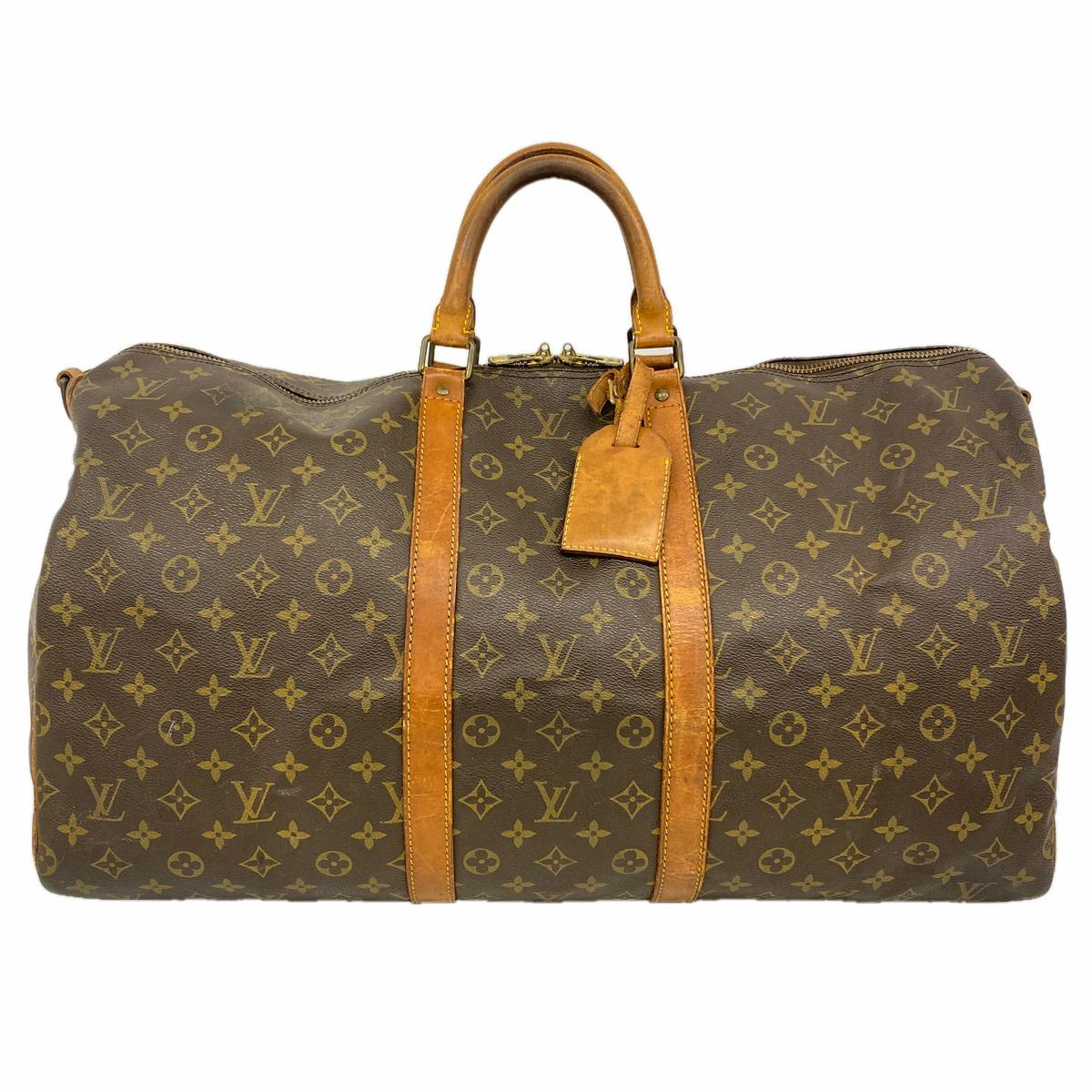 Brown Louis Vuitton monogram duffel bag with leather handles, straps, and an attached luggage tag.