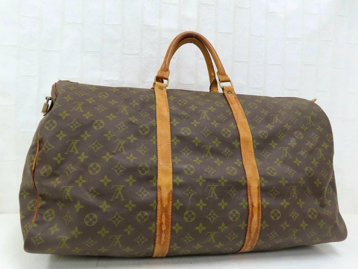 Front view of a brown Louis Vuitton monogram duffel bag with natural leather handles and straps.