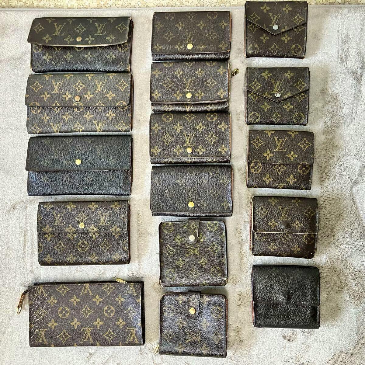 Multiple Louis Vuitton monogram wallets, coin cases, and pouches arranged on a light fabric surface.