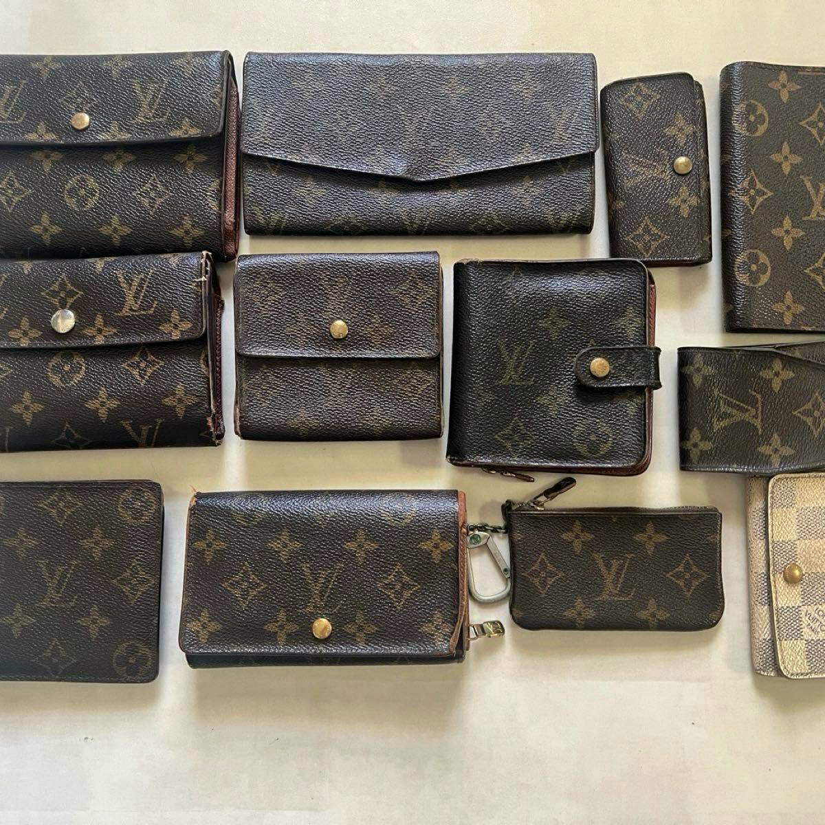 Multiple Louis Vuitton monogram wallets and small leather goods arranged flat, showing a set of wallets in varying sizes and conditions.