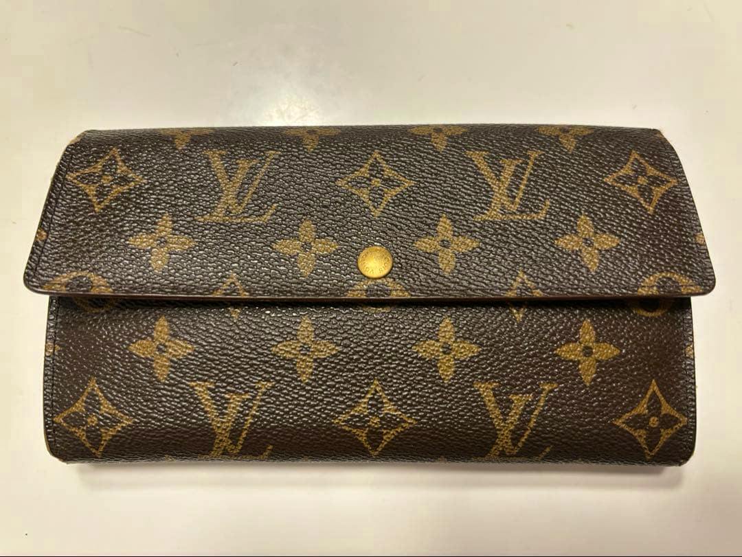 Front view of the Louis Vuitton Monogram long wallet M61215 made of cow leather showing the brown monogram pattern and snap closure.