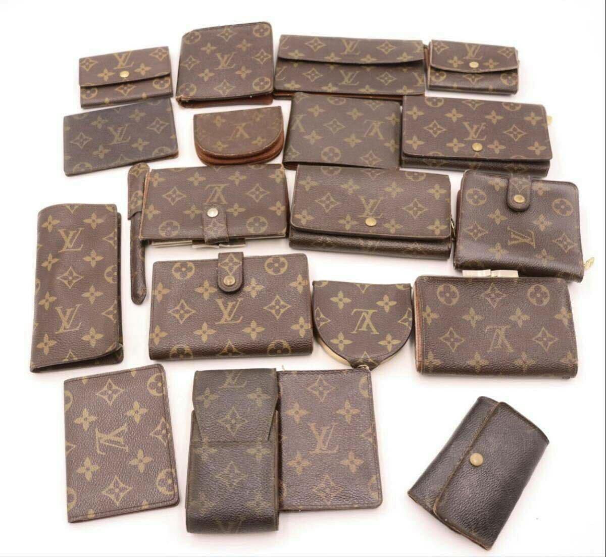 Several Louis Vuitton monogram wallets, coin cases, and small leather goods arranged on a white background.
