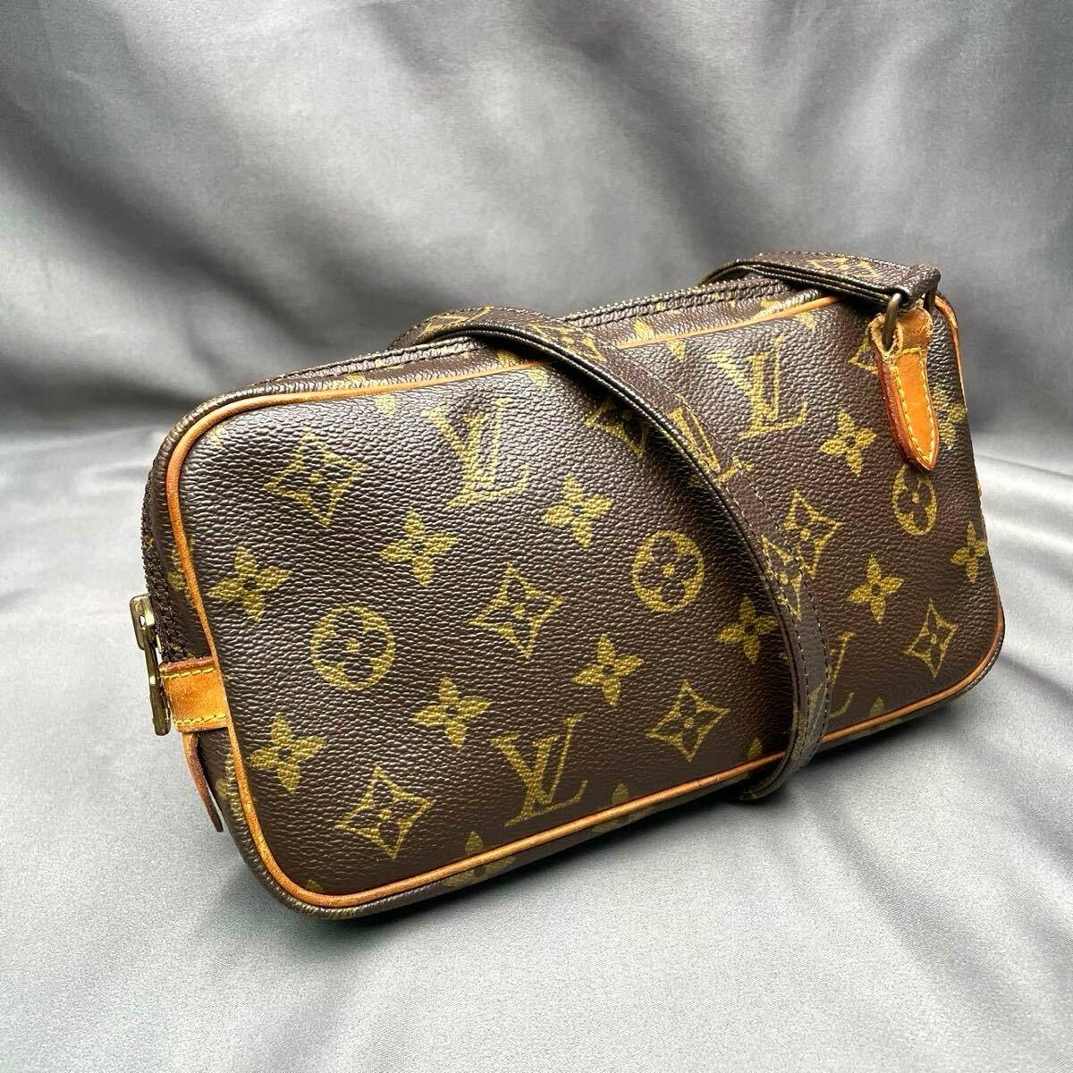 Louis Vuitton monogram shoulder bag (M51828) placed on a gray fabric background, showing the canvas pattern and strap.