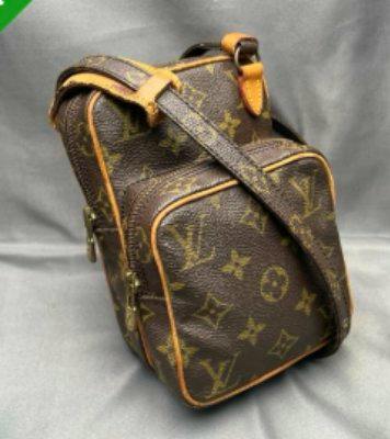 Monogram canvas Louis Vuitton mini Amazon shoulder bag shown at a three-quarter angle on a gray fabric background.
