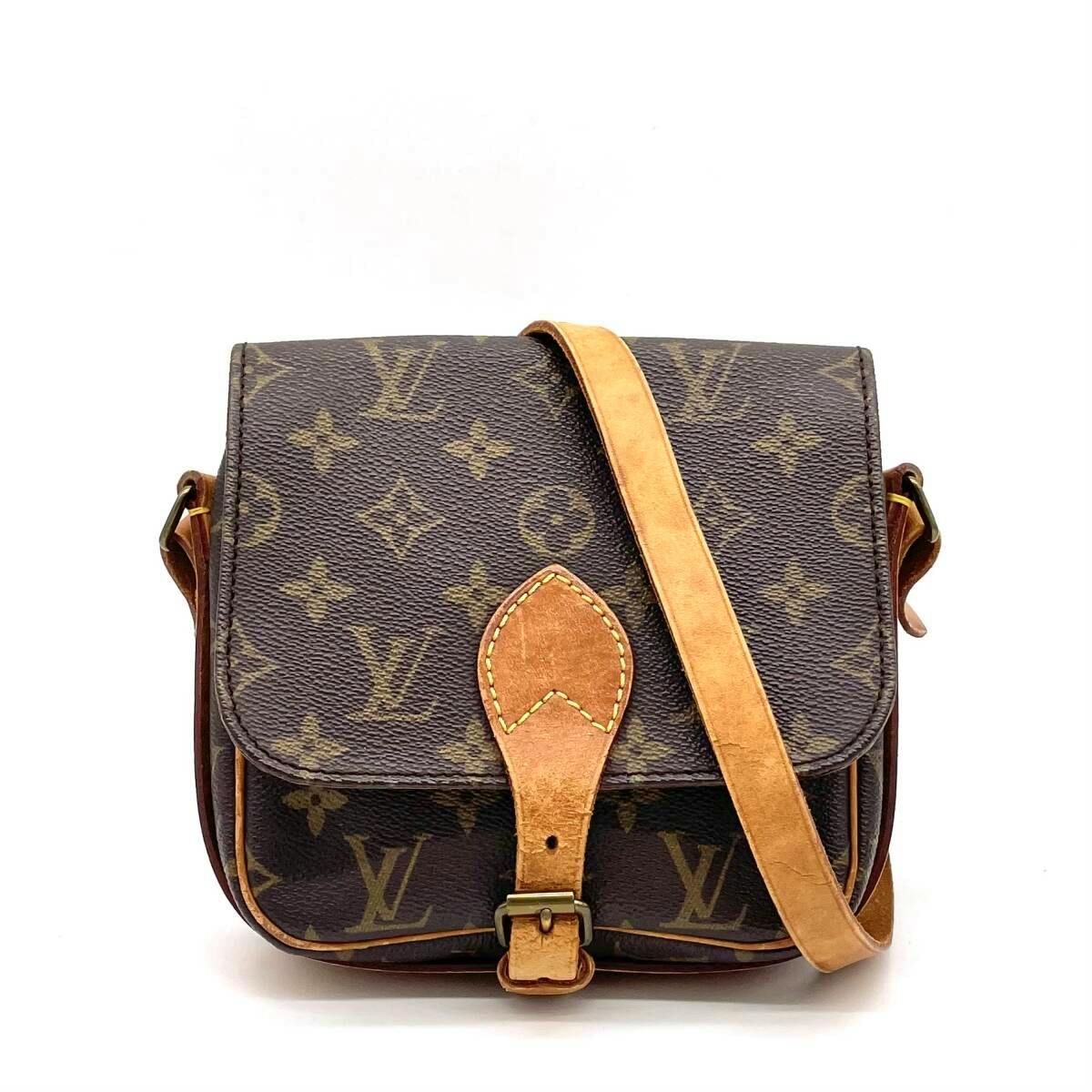 Front view of the Louis Vuitton Monogram Mini Cartouchiere crossbody bag (M51254) with cow leather strap and front buckle.