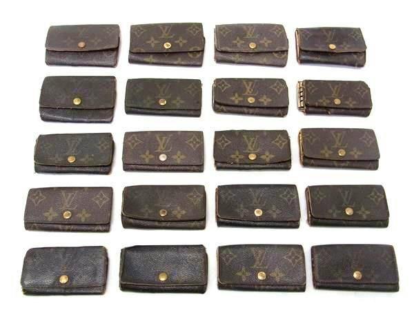 Twenty Louis Vuitton monogram key cases arranged in rows on a white background.
