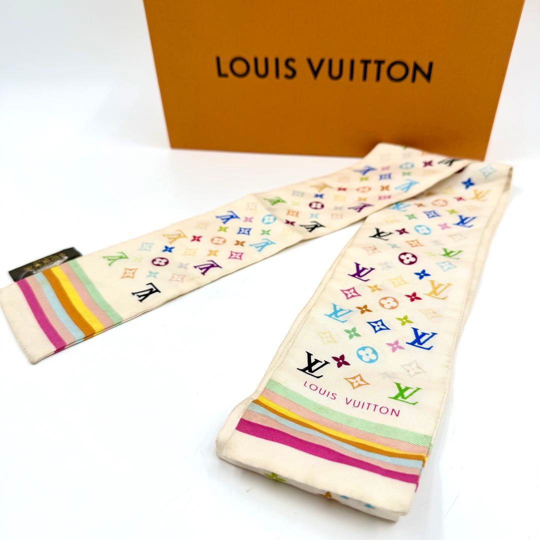 White Louis Vuitton multicolor monogram silk bandeau scarf displayed near an orange Louis Vuitton box.