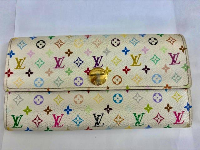Front exterior of the LOUIS VUITTON Monogram Multicolor long wallet in white showing multicolored LV pattern and a gold snap closure.