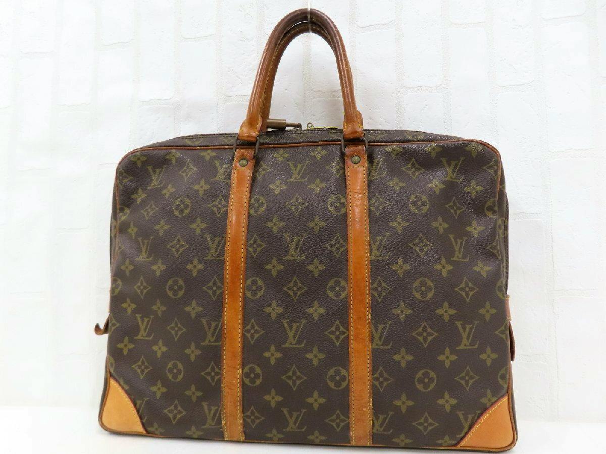 Front view of a brown Louis Vuitton monogram canvas business bag with leather handles and leather trim.