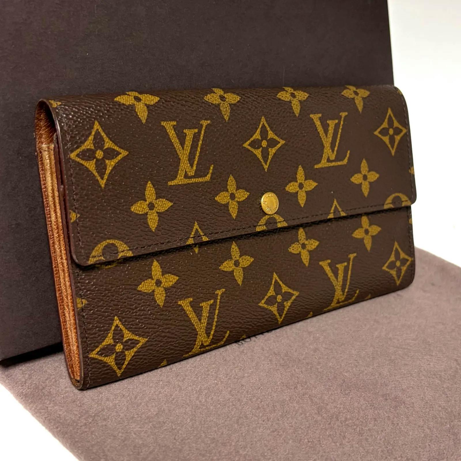Brown Louis Vuitton monogram two-fold wallet with flap and button closure.