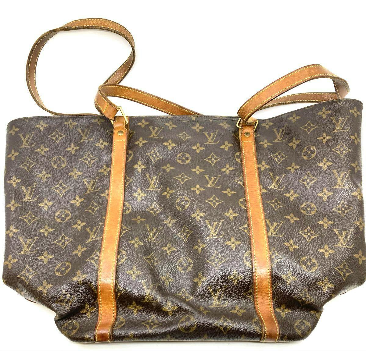Louis Vuitton monogram canvas shopping tote bag with tan leather straps shown on a white background.