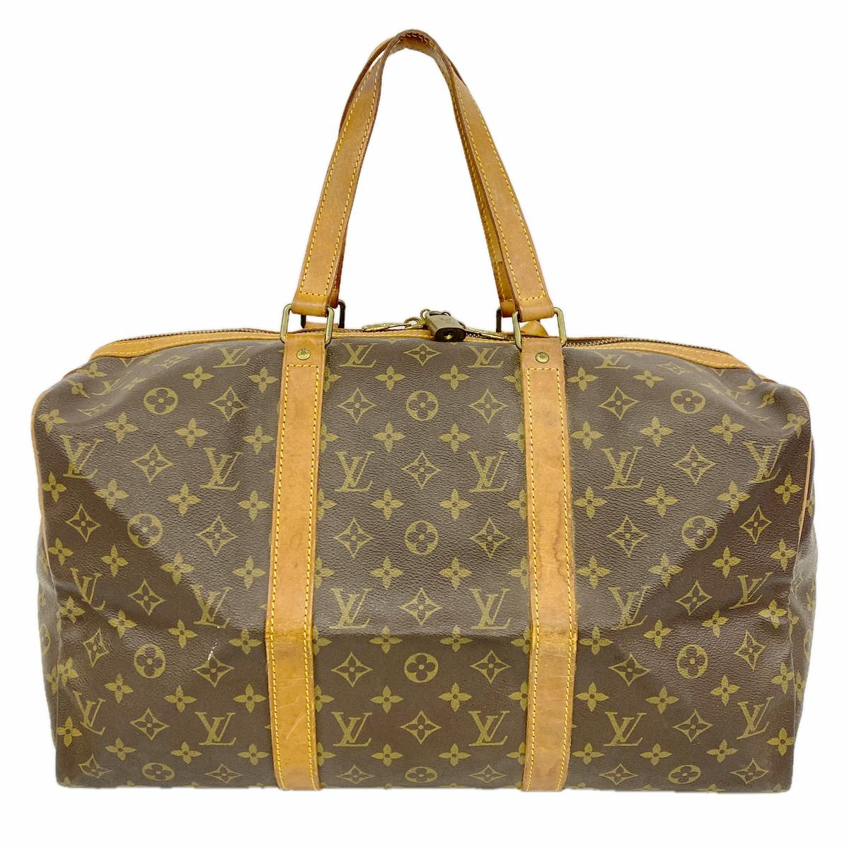 Front view of a Louis Vuitton monogram canvas Boston bag with patinated leather handles and top zipper.
