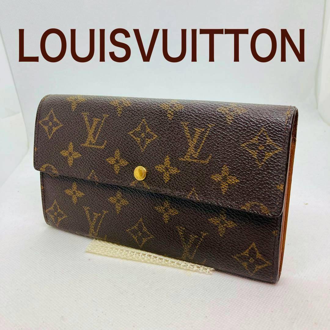 Closed Louis Vuitton monogram canvas long wallet with flap and gold snap button on a white background.