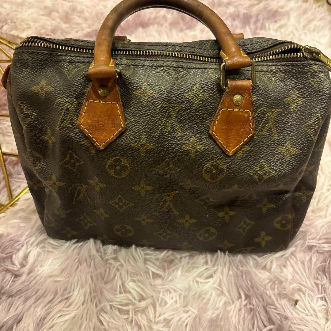 Front view of the LOUIS VUITTON モノグラム スピーディー25 handbag showing the monogram canvas, leather handles, and top zipper.