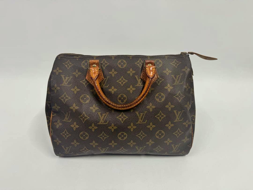 Front view of the LOUIS VUITTON Monogram Speedy 30 handbag (cow leather) on a plain background.