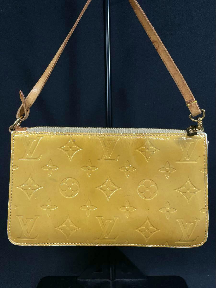 Front view of a yellow Louis Vuitton Monogram Vernis Lexington patent leather handbag with one handle and embossed LV monogram pattern.