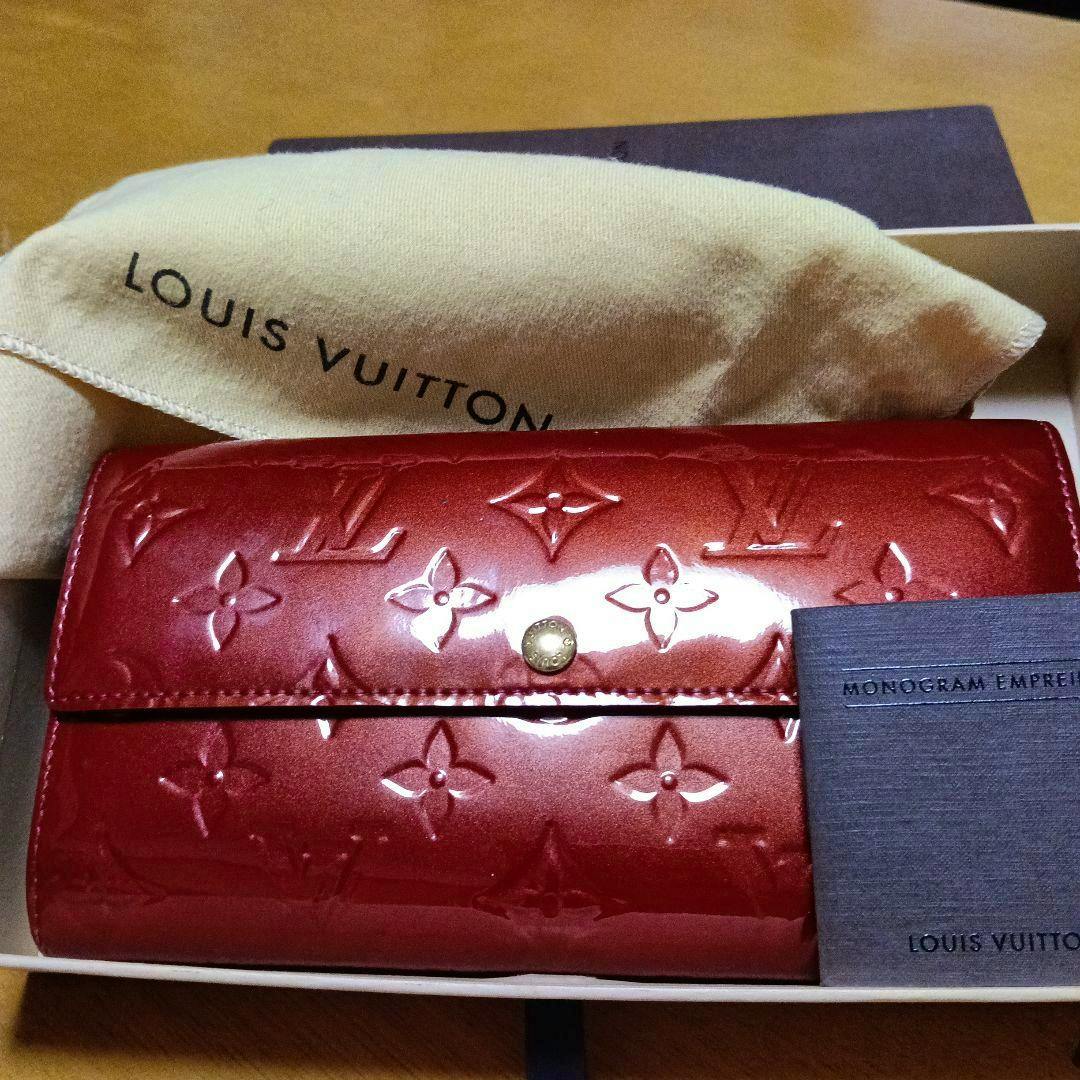 Red Louis Vuitton monogram Vernis long patent leather wallet shown in its box with a Louis Vuitton dust bag and booklet.