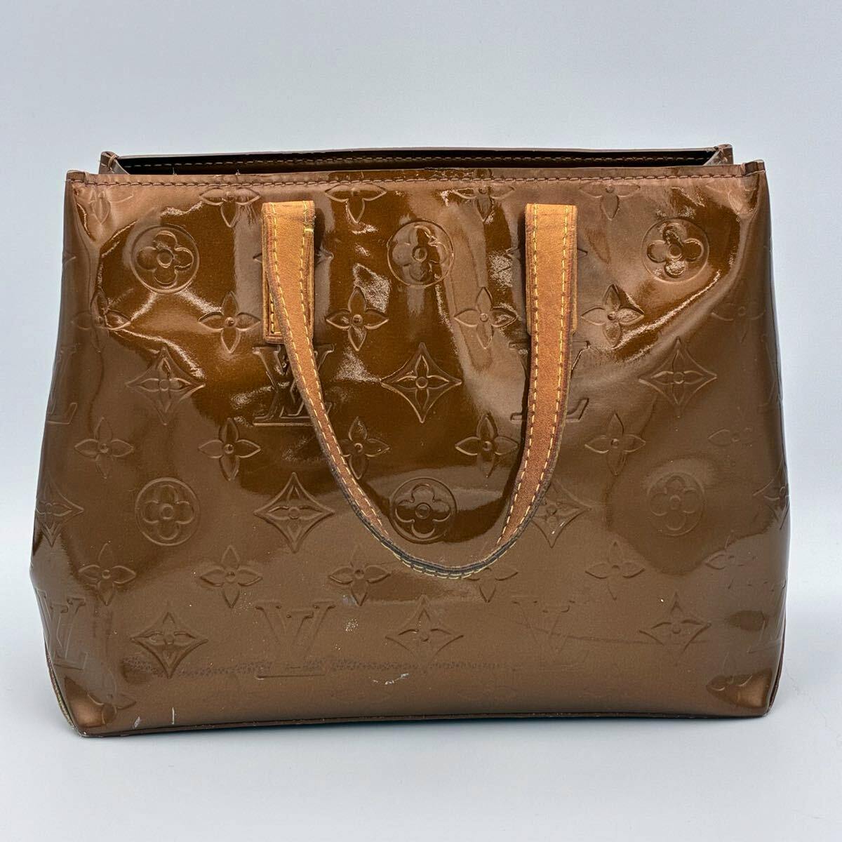 Front view of the bronze Louis Vuitton Monogram Vernis Reade PM handbag with embossed monogram pattern and twin leather handles.