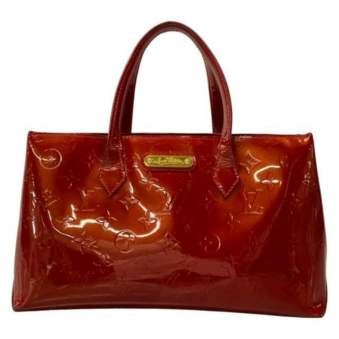 Front view of a red Louis Vuitton Monogram Vernis Wilshire PM tote bag with two top handles and a gold nameplate.