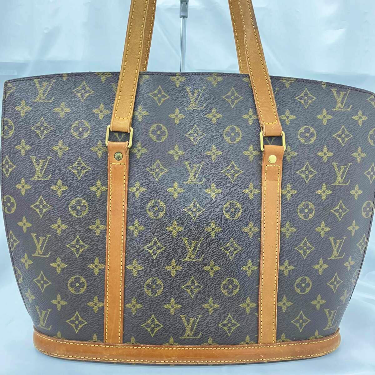 Front view of the Louis Vuitton Monogram Babylon shoulder bag showing monogram canvas and tan leather straps.
