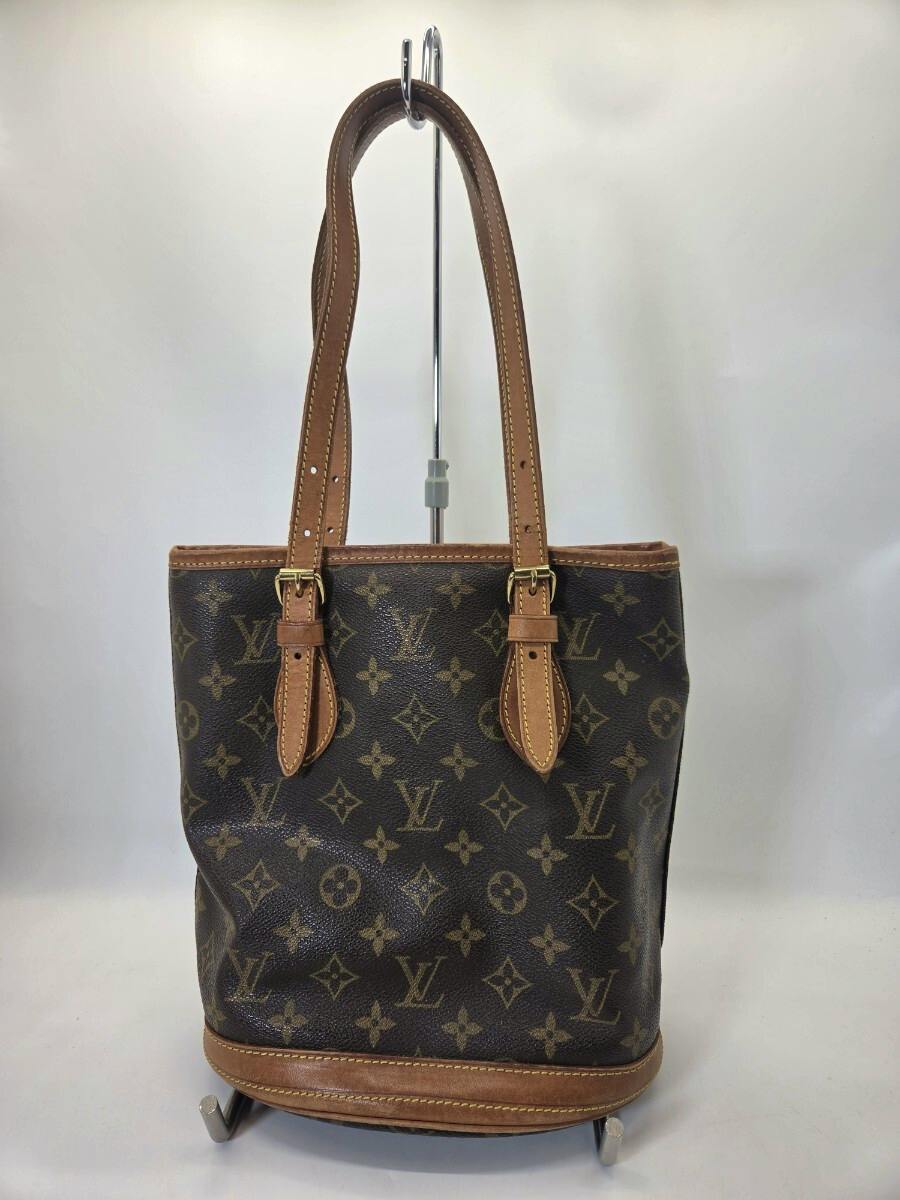 Front view of a Louis Vuitton monogram vintage handbag with two brown leather shoulder straps displayed on a stand.