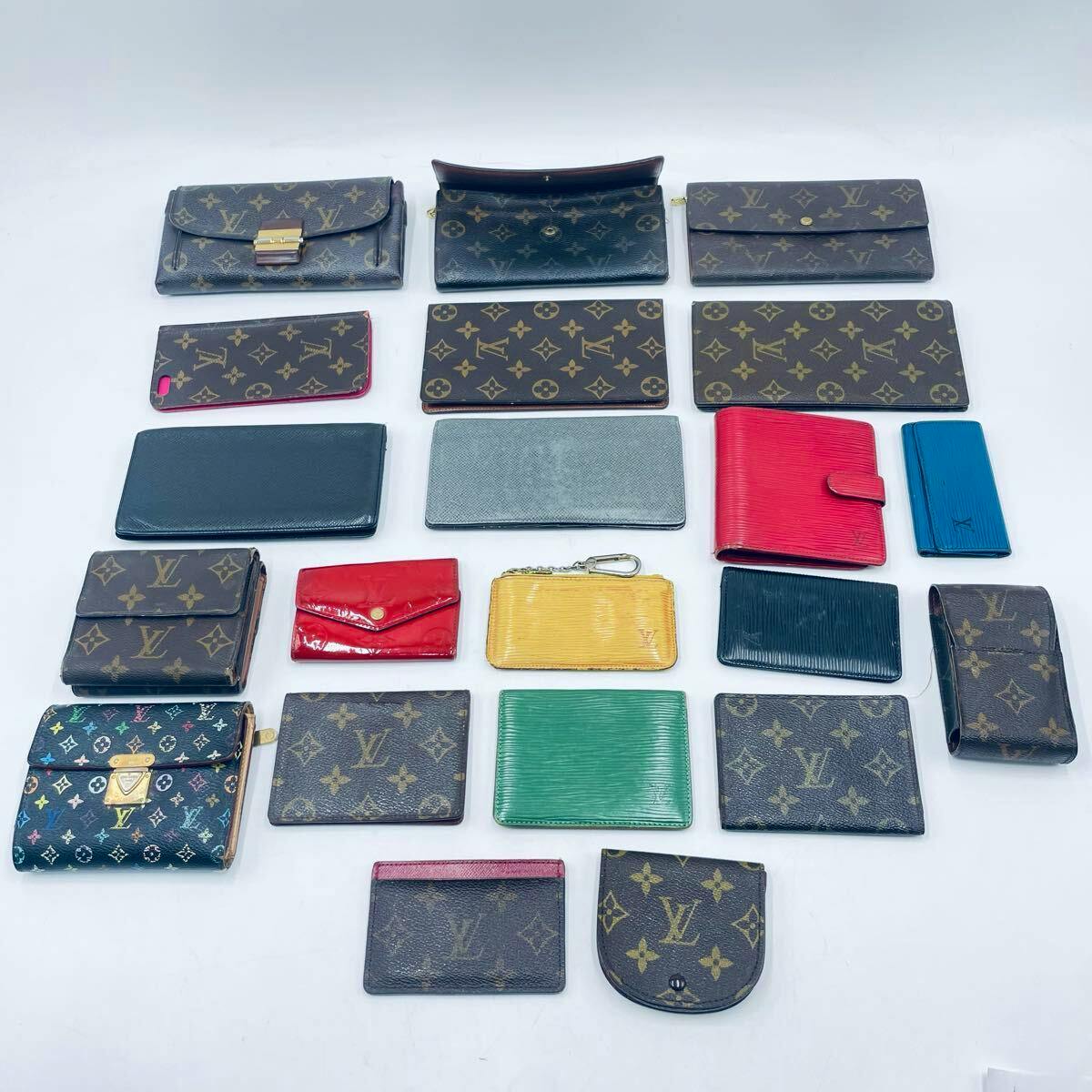 A flat lay of Louis Vuitton monogram wallets and small leather goods arranged on a white background.