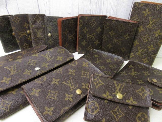 Multiple brown Louis Vuitton monogram wallets and small leather goods arranged on a white surface.
