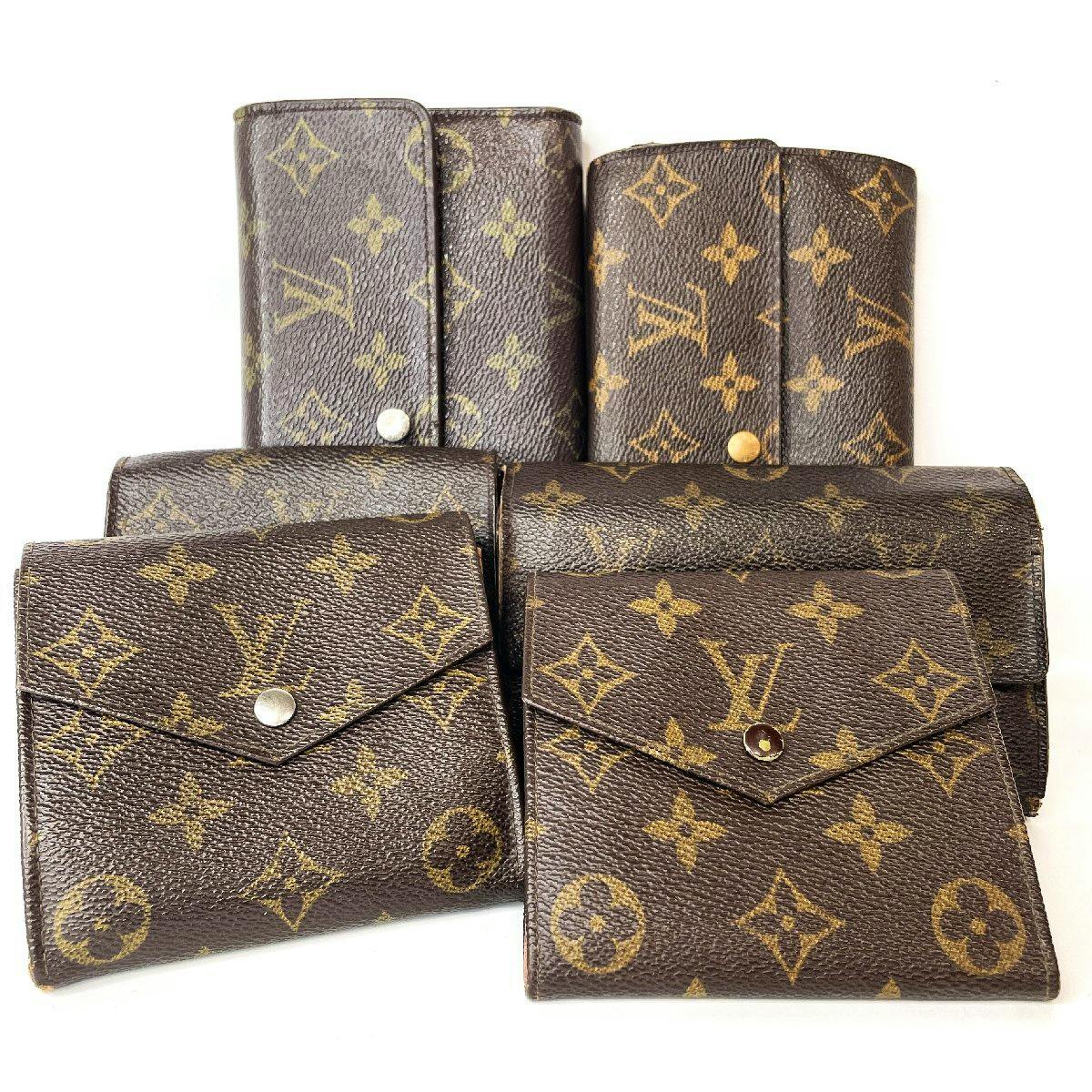 Six Louis Vuitton monogram wallets displayed together on a white background.