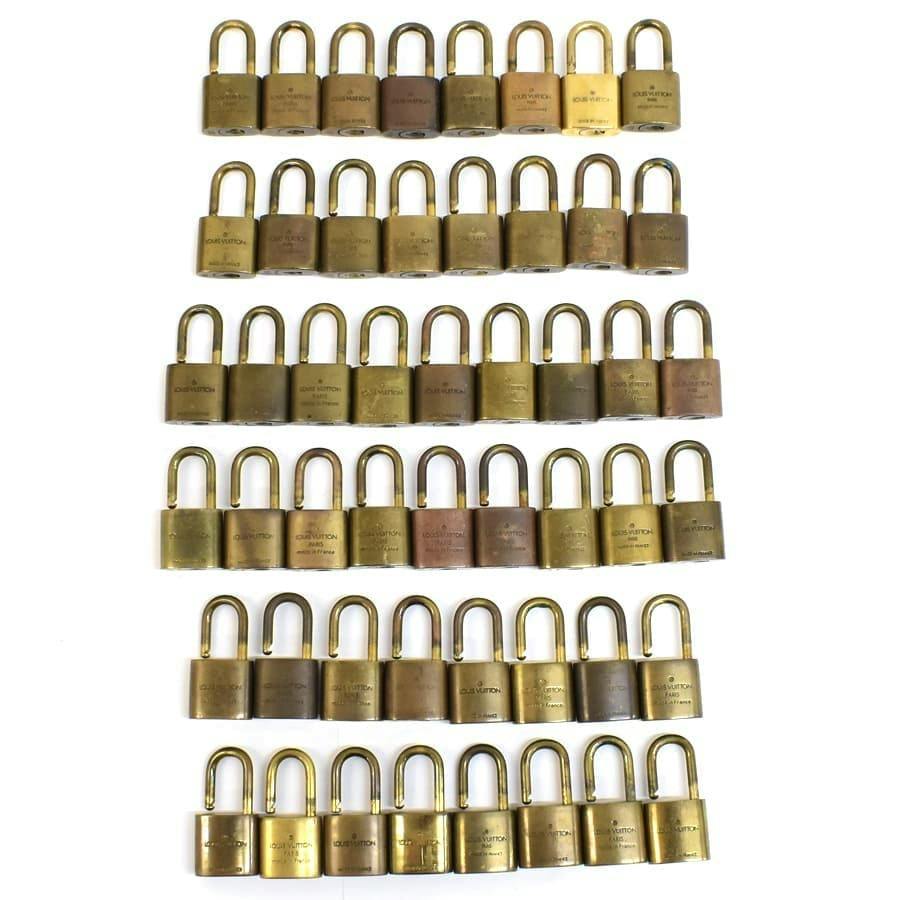 Multiple Louis Vuitton padlocks arranged in neat rows on a white background.