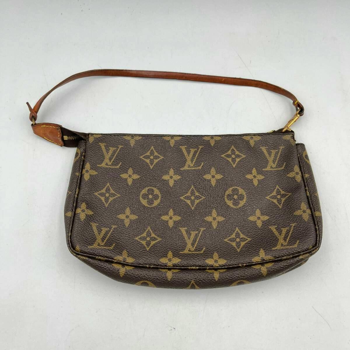 Front view of a Louis Vuitton monogram canvas pochette with a leather wrist strap on a white background.