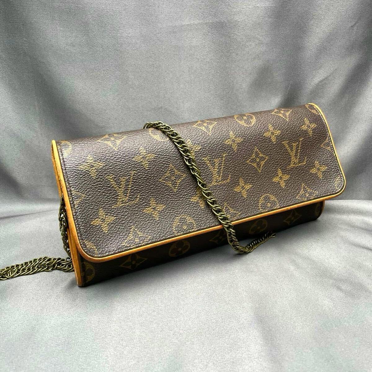 Louis Vuitton Monogram Pochette Twin GM shoulder bag with chain strap displayed on a gray backdrop.